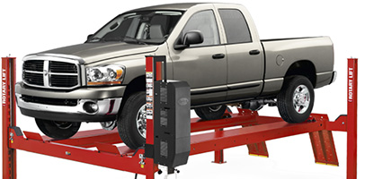 Gray truck elevated on a red four post SM14 Rotary Lift